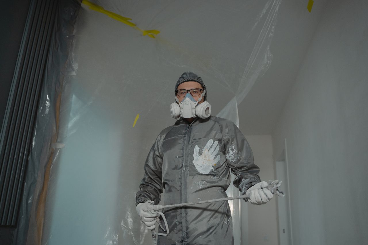 stats-img Painter in protective suit with mask and goggles preparing for indoor home renovation.